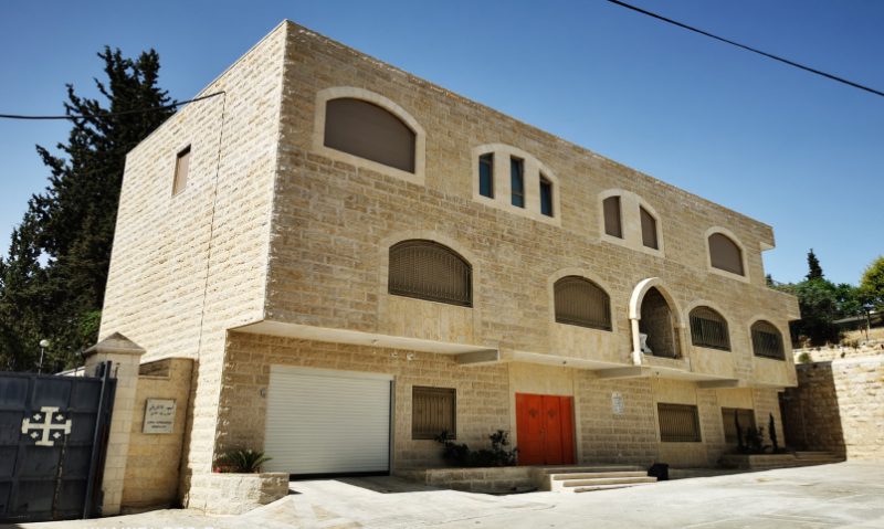 Maison des Sœurs du Rosaire à Beit Jala — extérieur en pierre claire avec porte rouge